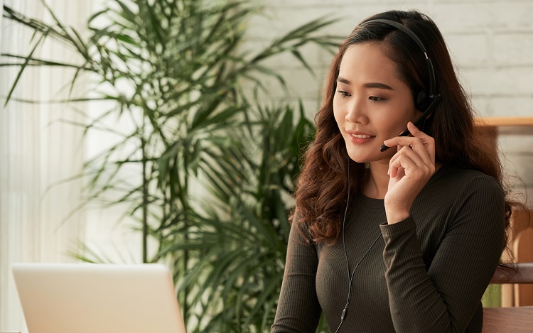 Smiling business woman in headset consulting clients